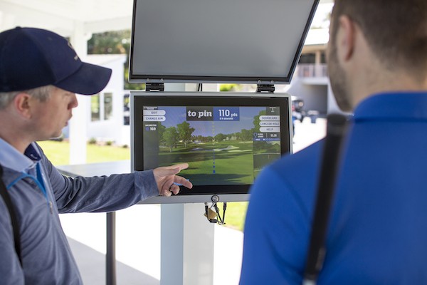 two male golfers analyzing the screen at the Toptracer Driving Range