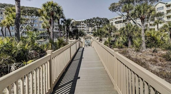 bridge walk into the community pool surrounded by buildings of a Palmetto Dunes Vacation Rental Home community