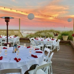 table and chair setup at a oceanside wedding reception during sunset