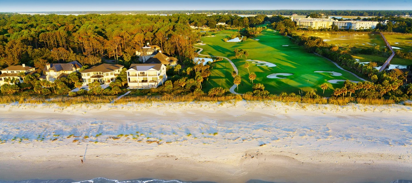 Aerial shot of ocean, beach, golf course, and vacation rental properties