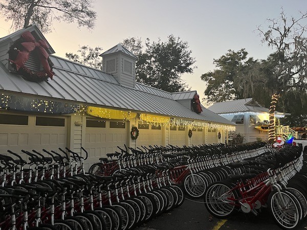 exterior of Hilton Head Outfitters garage with holiday lights and lines of red rental bikes