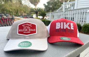 tan and red Hilton Head Island hats with Hilton Head Outfitters building and trees in the background