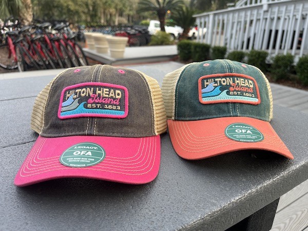 Hilton Head Island pink and orange trucker hats on display outside of Hilton Head Outfitters