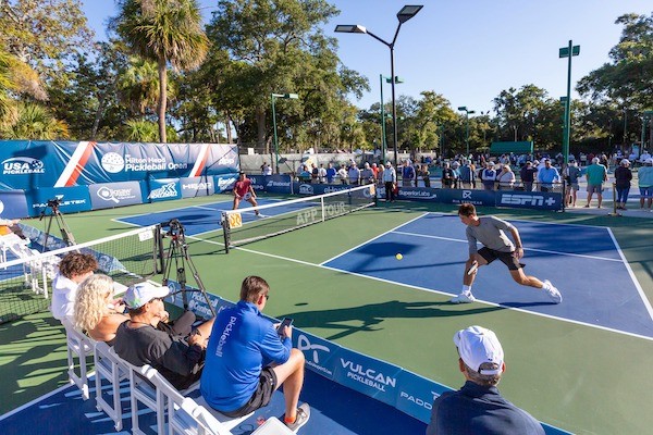 two pickleball players actively competing with spectators surrounding them