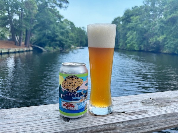 beer can and a tall beer glass on the railing at Alexander's overlooking the lagoon