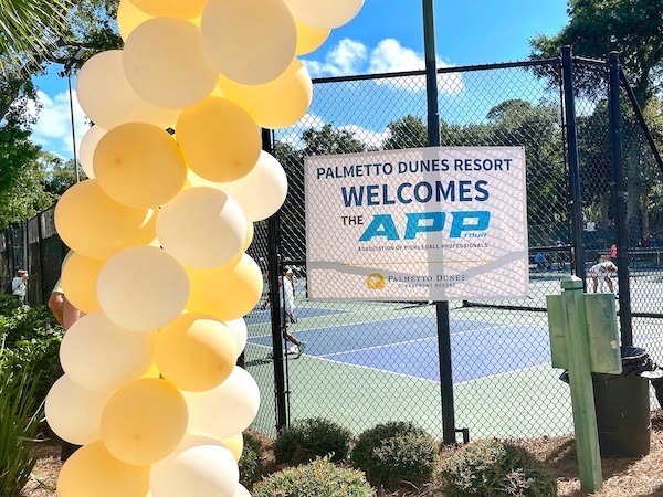 yellow balloons around the Palmetto Dunes APP Pickleball welcome sign on pickleball courts fence