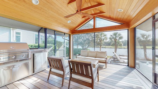 large screened in porch with large grill overlooking the lagoon