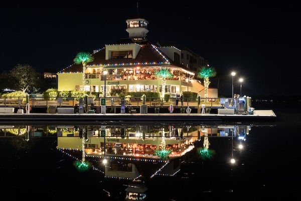 Shelter Cove Marina with holiday decorations at night with the reflection on the water