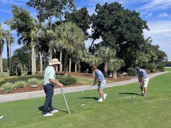 father and son practicing chipping with Doug Weaver