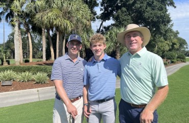 father and son with Doug Weaver on the greens of a golf lesson