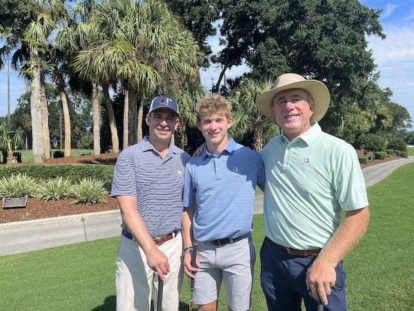 father and son with Doug Weaver on the greens of a golf lesson