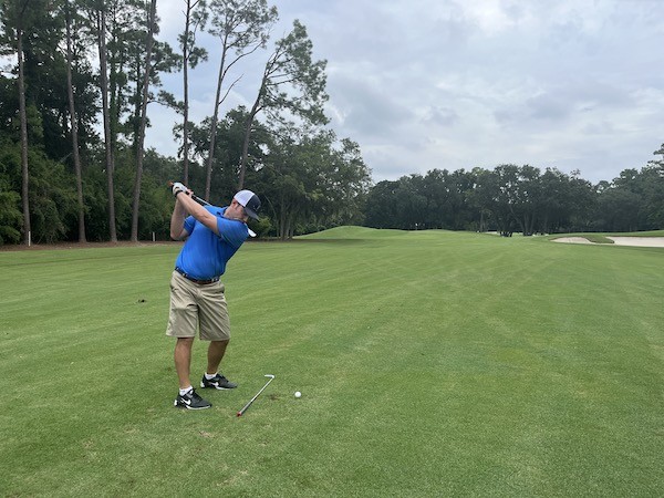 golfer mid swing during golf lesson at Palmetto Dunes