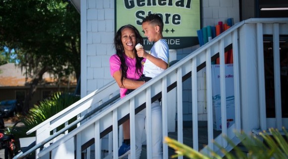 mom holding son eating ice cream on the steps of the General Store