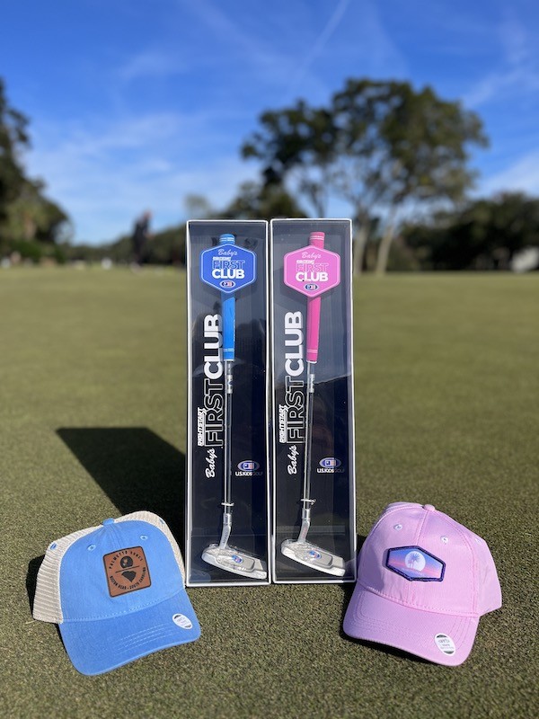 blue and pink First Club putters with kid hats on the green