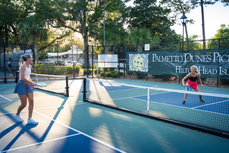 two girls actively playing pickleball on Palmetto Dunes Pickleball court