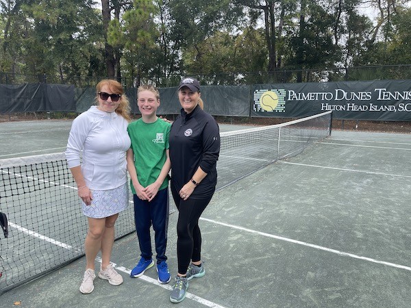 Skylar, his mom, and Dr. Yulia posing on the tennis courts of Palmetto Dunes Tennis Center