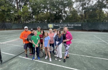 group of family and friends holding tennis rackets on the Palmetto Dunes Tennis Courts