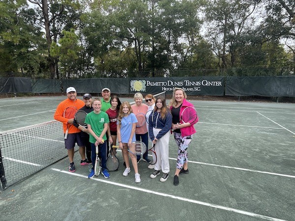 group of family and friends holding tennis rackets on the Palmetto Dunes Tennis Courts