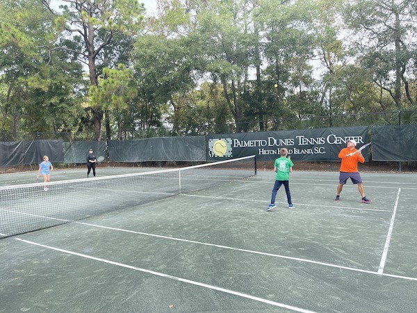 group actively playing tennis on Palmetto Dunes Tennis Court