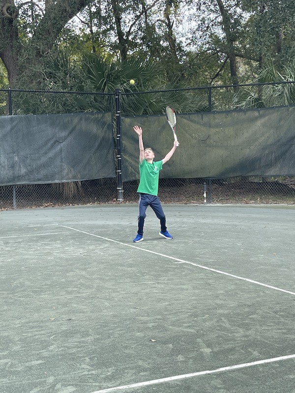Skylar serving the tennis ball on the tennis court