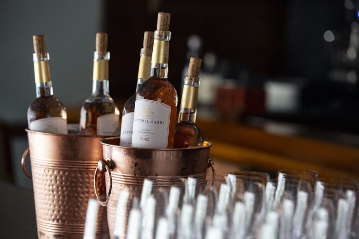 several wine bottles chilling in rose gold wine buckets