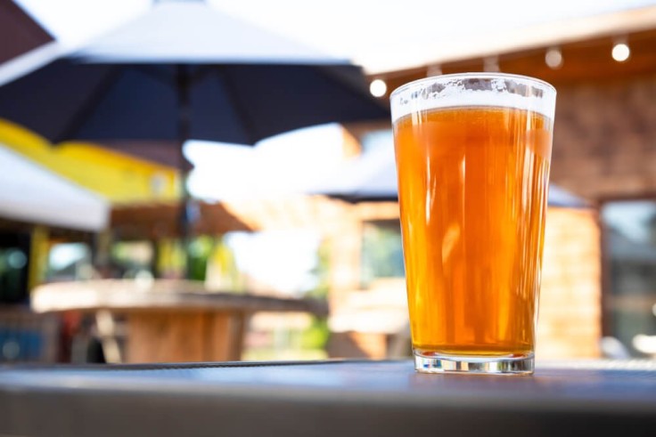 close up of amber beer with umbrella and table in background