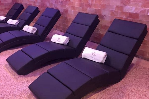 Heated lounge chairs in pink salt room of pure salt spa