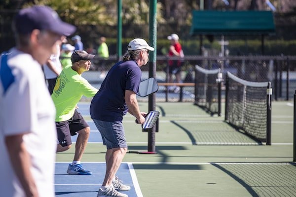 Pickleball players anticipating a serve on the courts