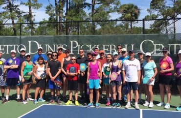 group of pickleball players  posing on pickleball court
