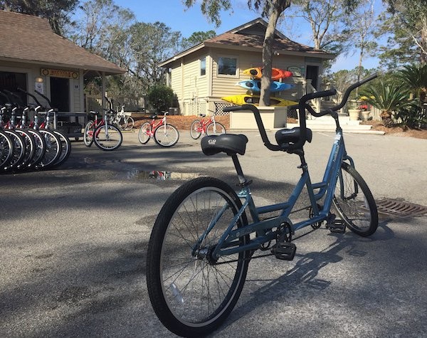 blue tandem bike in front of outfitters exterior