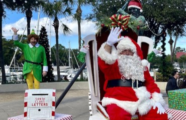 santa waving at Shelter Cove Marina with elf in the background