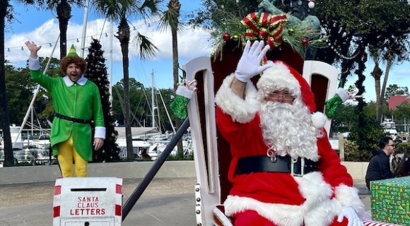 santa waving at Shelter Cove Marina with elf in the background