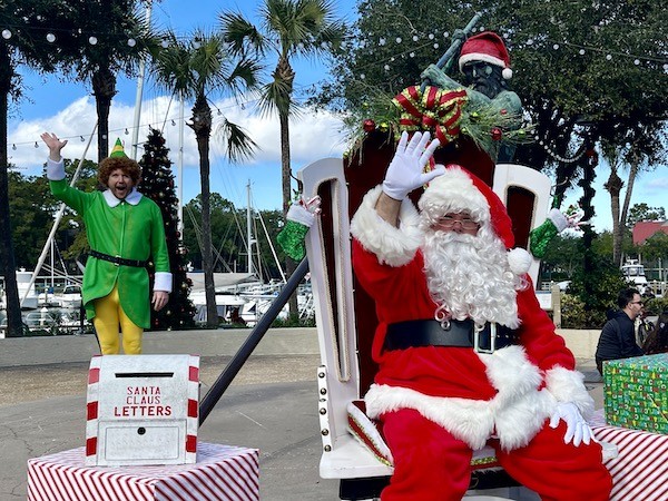 santa waving at Shelter Cove Marina with elf in the background