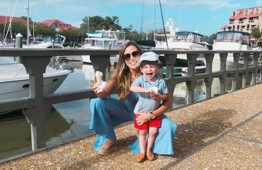 mom and son enjoying ice cream at the marina with boats in the background
