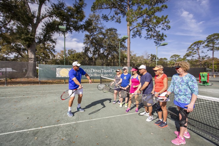 Palmetto Dunes Tennis Instructor teaching students a swing technique on the court