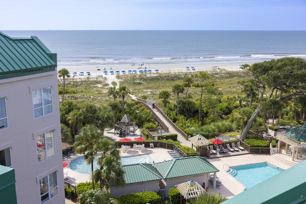 view of the beach and two pools from a balcony in the Windsor Court Oceanfront Complex