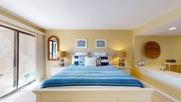 yellow bedroom with a king bedroom and large sliding doors of a Palmetto Dunes Vacation Rental