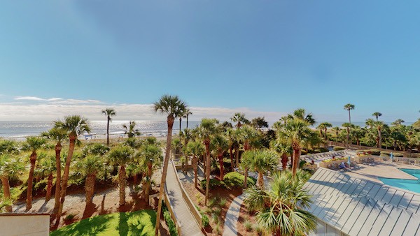 view of the pool complex and the ocean from the private deck of a Palmetto Dunes Oceanfront Vacation Rental