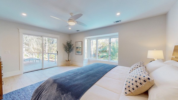 master bedroom with two large windows and deck access