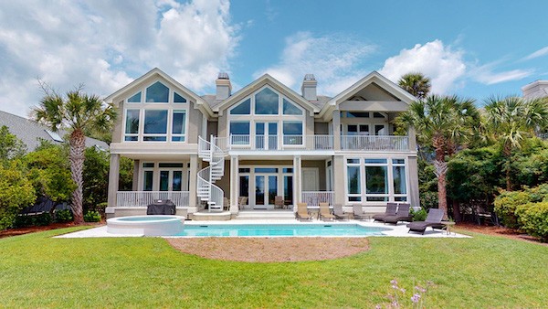 Rear exterior of a large Palmetto Dunes vacation home with a private pool and two story deck