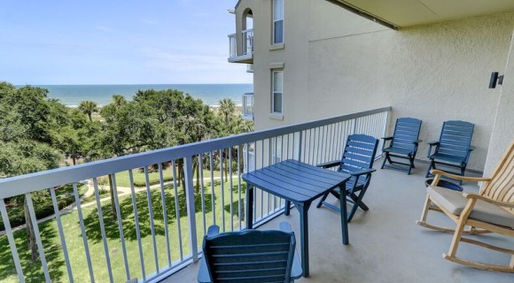 chairs on private balcony overlooking the landscaping and ocean