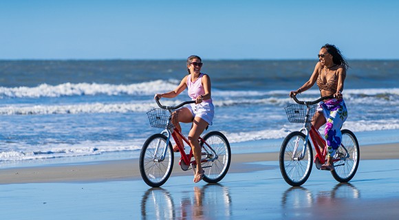 Girls biking on the beach