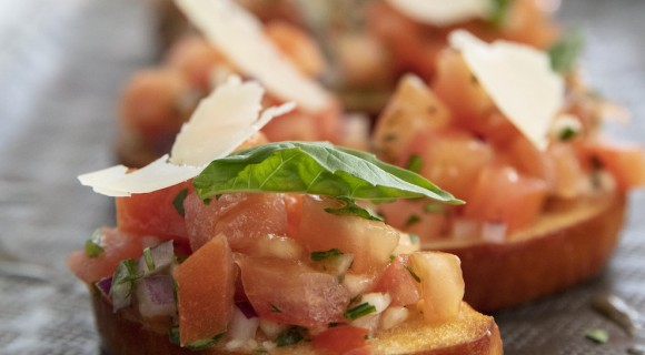 close up of bruschetta on flat bread with shaved parmesan for Dunes Catering