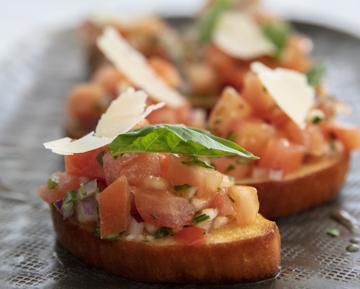 close up of bruschetta on flat bread with shaved parmesan for Dunes Catering