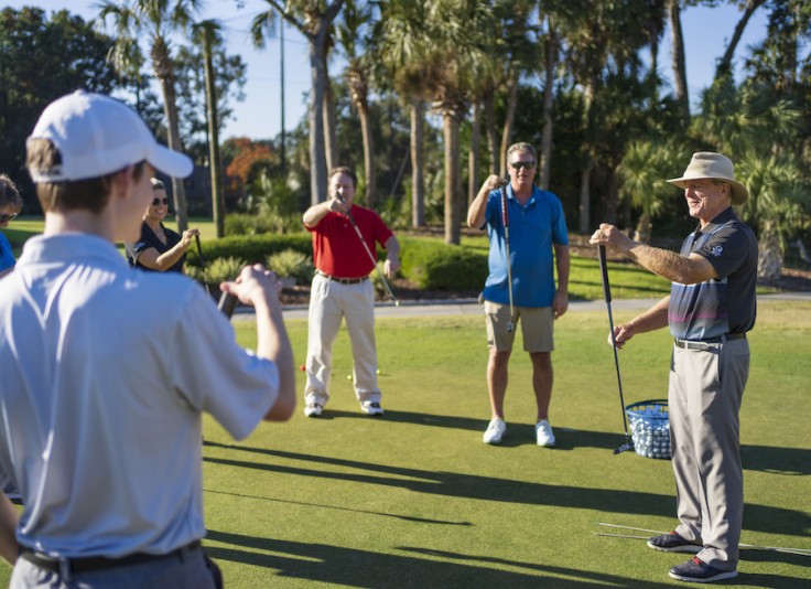 Doug Weaver demonstrating with a putter in front of a group at golf lessons at Palmetto Dunes Golf Academy