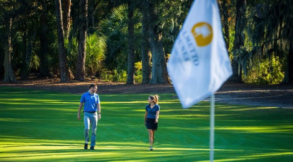 male and femal golfer walking towards flag on Palmetto Dunes Golf Course