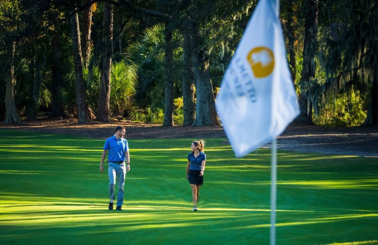male and femal golfer walking towards flag on Palmetto Dunes Golf Course