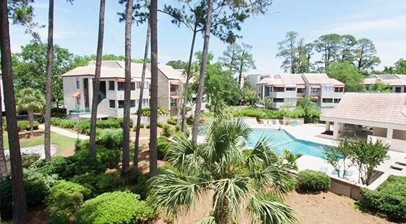 view of pool and trees from private balcony