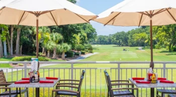 dining table and umbrellas on Big Jim's balcony overlooking the golf course