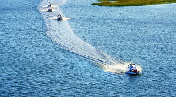 Four small boats speeding through Broad Creek